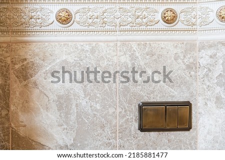 stylish designer light switches on a tile wall