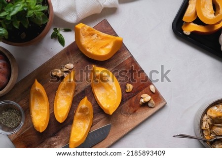 Top view of fresh, orange pumpkin slices on cutting board. Cooking ingredients for a butternut soup, pie or autumn foods.