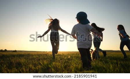 happy family. people in the park. children child running together in the park on the grass silhouette. daughter and son are running. happy family and little child in summer. concept sunset dream