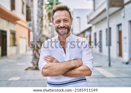 Middle age man outdoor at the city happy face smiling with crossed arms looking at the camera. positive person. 