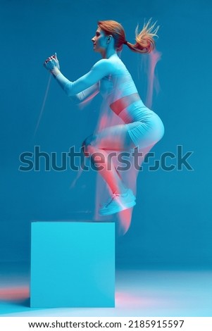 Athlete sportive girl jumping to cube platform. Intensive workout for endurance. Long exposure, motion blur