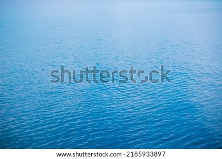 Abstraction of the surface of blue water reflected by sunlight as a background.Top view of the sea water. The concept of relaxing on the beach, vacations. Ripples on the water.