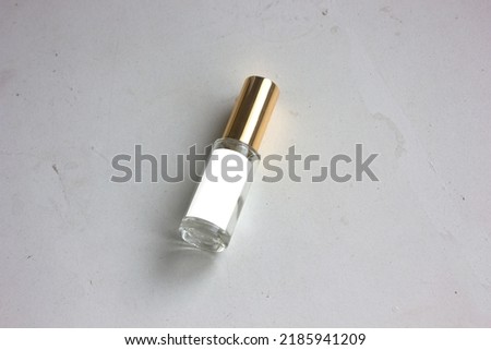 The glass tube perfume with elegant gold lid, is isolated on textured white background, for glamour cosmetic branding design mockup.