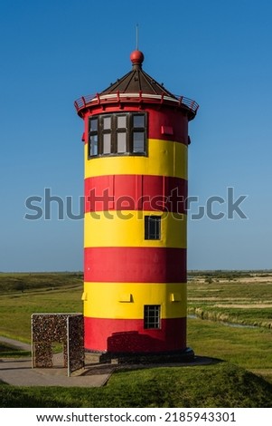 Pilsum lighthouse on the flood dam near Pilsum, East Frisia, Germany Royalty-Free Stock Photo #2185943301