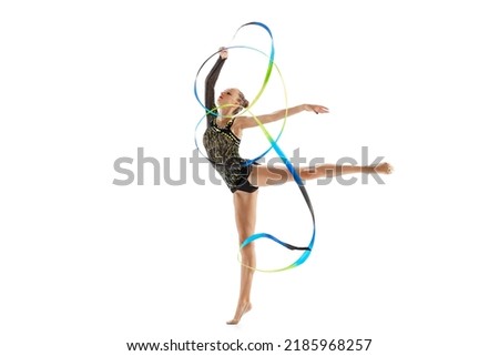 Young beautiful sportive girl, female rhythmic gymnast training with colorful ribbons isolated over white studio background. Concept of action, motion, sport life, competition. Copyspace for ad Royalty-Free Stock Photo #2185968257