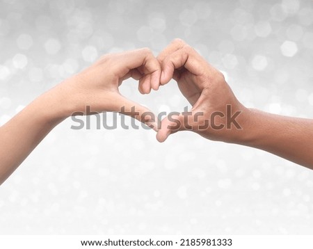 Couple making heart shape with hand on shining bokeh background