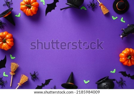 Happy Halloween holiday concept. Frame made of Halloween decor, pumpkins, spiders, bats, witch brooms, pots, hats on purple background. Flat lay, top view, view from above.
