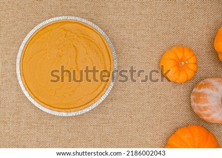 Pumpkin pie recipe. Pumpkin puree and crust in disposable baking pan, ready to be baked. Close up view from above