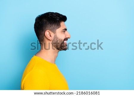 Photo of good mood man wear yellow sweater smiling looking empty space isolated blue color background Royalty-Free Stock Photo #2186016081