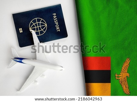 Flag of Zambia with passport and toy airplane. Flight travel concept 