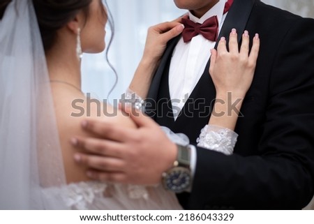 hands of the bride and groom on a bow tie on the wedding day. concept for wedding event agencies
