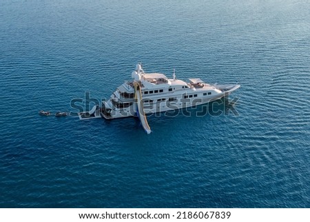 Big luxury white yacht anchoring in shallow water stands in the sea at sunset. Travel and vacation concept, marine entertainment Royalty-Free Stock Photo #2186067839
