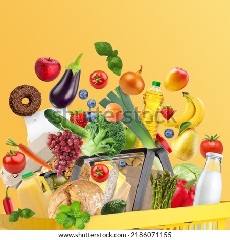 Yellow shopping basket with fresh food full of variety of grocery products, food and drink on yellow background. Supermarket food concept. Home delivery. Vegetables, products that flying out of basket Royalty-Free Stock Photo #2186071155