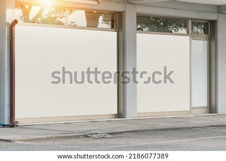 Empty white banner with space for mock up mounted on window case of supermarket or fashion outlet