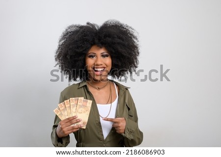 woman holding money, brazilian money, on gray background