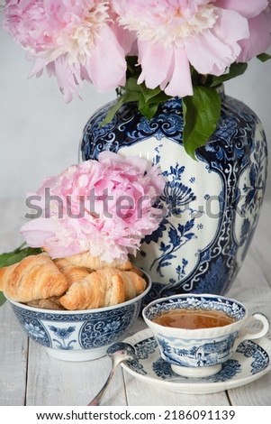 delicate spring still life with croissants and a bouquet of pink peonies 