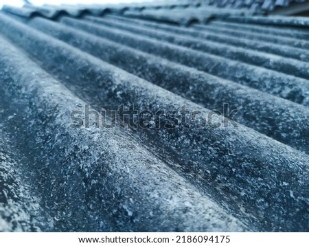 The roof of the house is made of asbestos which is weathered by age and weather Royalty-Free Stock Photo #2186094175