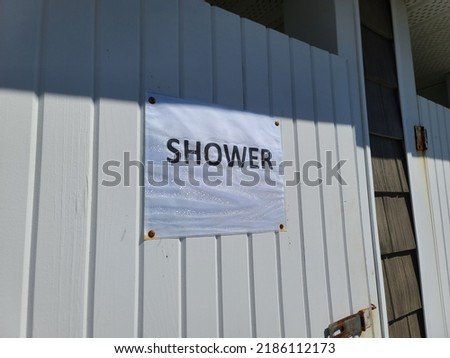 A sign that says shower hanging on a white door.