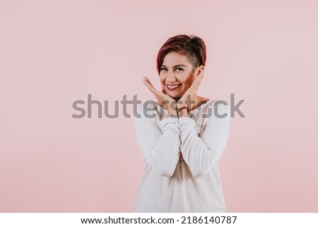 portrait of young hispanic girl posing on coral pink background in Mexico Latin America
