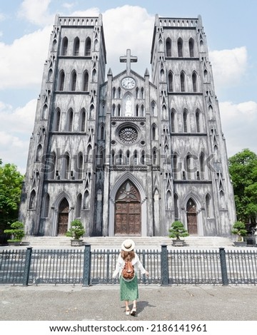 Woman traveller is sightseeing at St Joseph's Cathedral (Nha Tho Lon in Vietnamese) in Hanoi, Vietnam Royalty-Free Stock Photo #2186141961