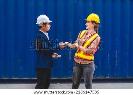 Professional two engineer container cargo foreman in helmets working standing and using walkie talkie checking stock into container for loading.logistic transport and business industry export