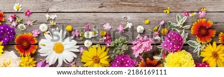 Garden flowers over wide wooden table background. Flat lay