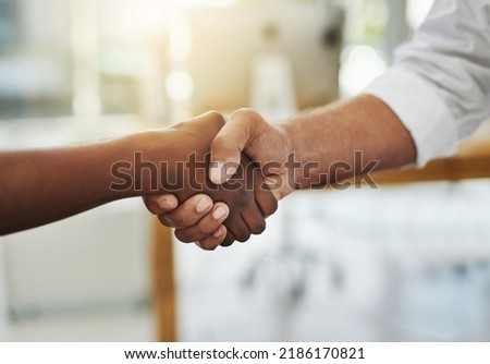 A team handshake in agreement between colleagues and coworkers in an office. Working together as a team to achieve success, merge as a partnership or promote a business person at work closeup Royalty-Free Stock Photo #2186170821