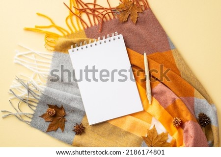 Autumn mood concept. Top view photo of diary pen anise yellow maple leaves pine cones and plaid on isolated pastel beige background with empty space