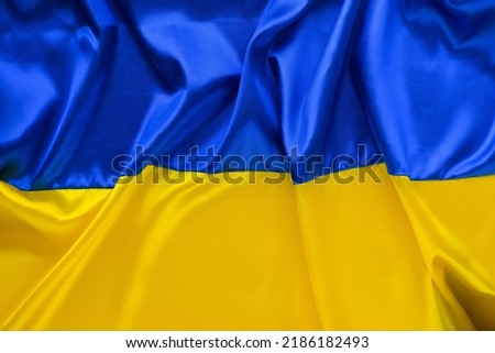 Fabric wave flag of Ukraine, UA. Blue and yellow bright colors. Close up curved texture background