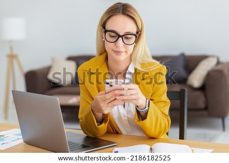 Beautiful woman working using computer laptop and mobile phone, concentrated sitting in modern office, online remote work, young entrepreneur, small business owner Royalty-Free Stock Photo #2186182525