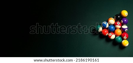 Pyramid made of billiard balls on dark background with space for text
