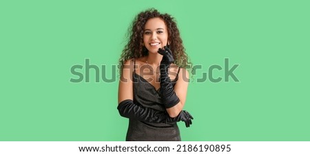 Elegant African-American woman on green background 