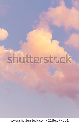 Vertical shoot.Light pink clouds in sunset blue sky. Pastel colors of clouds, sunrise sundown natural background.Pink purple clouds in blue sky while sunset twilight magic happening in nature, defocus Royalty-Free Stock Photo #2186197301