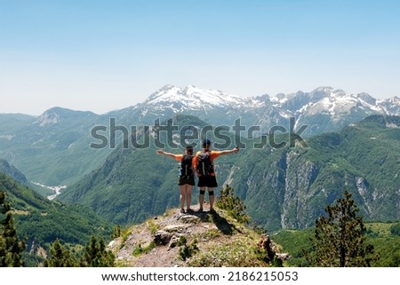 A couple of tourists rest on a meadow in the mountains of Albania. Mountains on the north Albania Royalty-Free Stock Photo #2186215053
