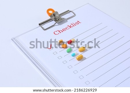 Different medical pills lay on checklist. Concept of taking pills on time, regularly, 