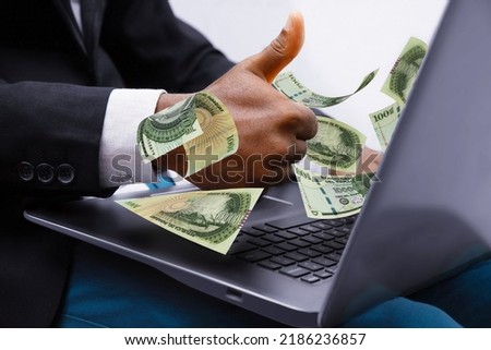 100000 Paraguayan guarani notes coming out of laptop with Business man giving thumbs up, Financial concept. Make money on the Internet, working with a laptop