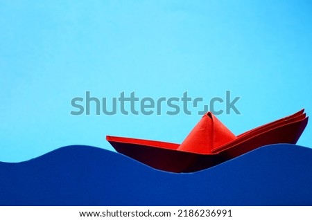 red paper boat on blue background