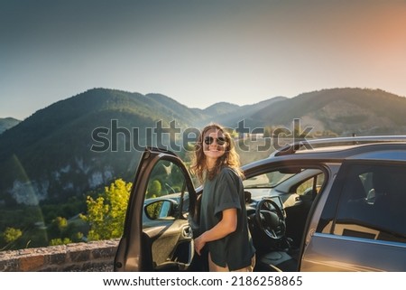 Young beautiful woman traveling by car in the mountains, summer vacation and adventure Royalty-Free Stock Photo #2186258865