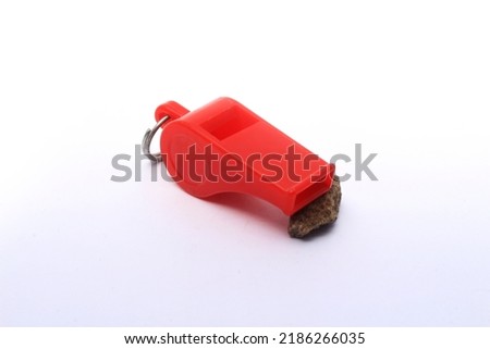whistle, a red whistle, generally this object is used to give or convey a signal in an activity, especially a tournament or sporting match.