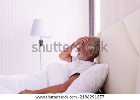 Senior man having migraine or headache pain in bedroom,Elderly healthy concept Royalty-Free Stock Photo #2186291377