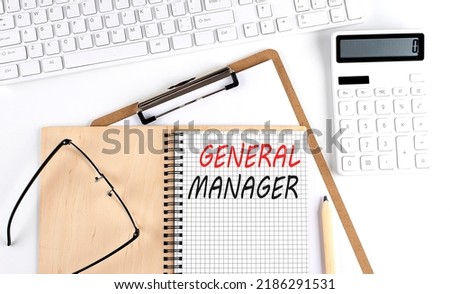 Notebook with the word GENERAL MANAGER with keyboard and calculator on white background