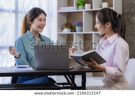 Starting a business, two young Asian women discuss working on investment projects and planning strategies. Businessman talking with laptop computer at office