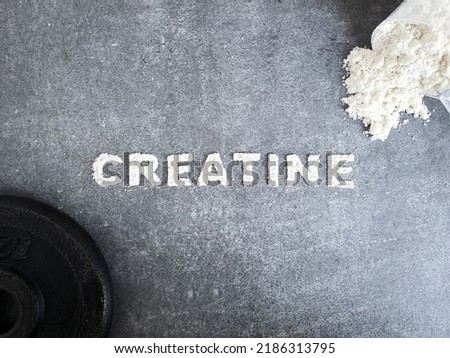 Creatine powder text font for Creatin popular sports supplement used to icrese muscle mass on stone background with scoop of creatine powder and sumbbell concept Royalty-Free Stock Photo #2186313795