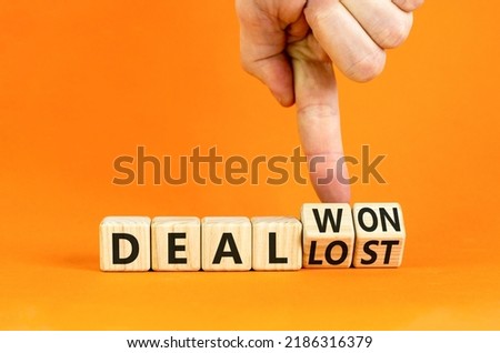 Deal lost or won symbol. Businessman turns wooden cubes and changes words 'deal lost' to 'deal won'. Beautiful orange background, copy space. Business and deal lost or won concept. Royalty-Free Stock Photo #2186316379