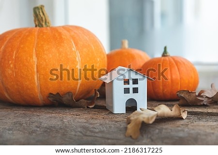 Autumnal Background. Toy house and pumpkin on wooden background. Thanksgiving banner copy space. Hygge mood, change of seasons concept. Hello Autumn with family Halloween party Royalty-Free Stock Photo #2186317225
