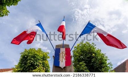 French flags around a tricolor badge bearing the acronym RF, traditional shortcut for "French Republic", on top of a WWI monument. Concepts of French patriotism and nationalism Royalty-Free Stock Photo #2186338771