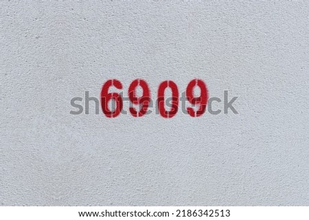 Red Number 6909 on the white wall. Spray paint.
