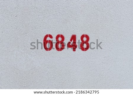 Red Number 6848 on the white wall. Spray paint.
