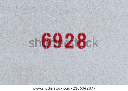 Red Number 6928 on the white wall. Spray paint.
