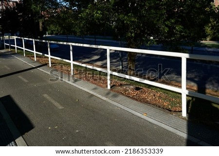 white metallic fence of tubular structure next to the bike lane